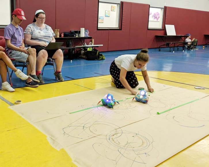 Facilitator is preparing the space for a co-design activity in a gym.